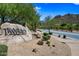 The Tramonto community entrance featuring a stone sign surrounded by desert vegetation at 2638 W Sat Nam Way, Phoenix, AZ 85086