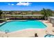 Sparkling community pool surrounded by lush landscaping with lounge chairs, tables, and relaxing desert views at 2638 W Sat Nam Way, Phoenix, AZ 85086