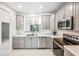 Well-lit kitchen with stainless steel appliances, grey cabinetry, and marble countertops at 2638 W Sat Nam Way, Phoenix, AZ 85086
