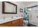 Bathroom with a wood vanity, framed mirror and a shower/tub combo with a stylish curtain at 3031 S Cortland --, Mesa, AZ 85212