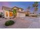 Charming two-story home featuring neutral tones, desert landscaping, and palm trees against a colorful sky at 3031 S Cortland --, Mesa, AZ 85212
