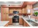 Well-equipped kitchen featuring wooden cabinets, stainless steel appliances, ample counter space, and modern lighting fixtures at 3031 S Cortland --, Mesa, AZ 85212
