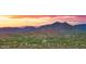 Elevated view of a desert community featuring golf course and homes at sunset with views of the mountains at 30600 N Pima Rd # 61, Scottsdale, AZ 85266
