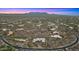 Aerial view of a sprawling desert community with custom homes under a dramatic sunset at 30600 N Pima Rd # 61, Scottsdale, AZ 85266