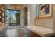 Bright bathroom featuring a soaking tub, stone floors, ceiling fan, and windows at 30600 N Pima Rd # 61, Scottsdale, AZ 85266