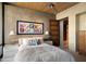 Stylish bedroom with a king-sized bed, modern art, and an open doorway that leads to another room at 30600 N Pima Rd # 61, Scottsdale, AZ 85266