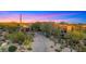Impressive desert home with lush desert landscaping and a private drive highlighted by a colorful twilight sky at 30600 N Pima Rd # 61, Scottsdale, AZ 85266