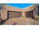 Spacious two-car garage with brown doors and a paved driveway at 30600 N Pima Rd # 61, Scottsdale, AZ 85266
