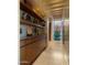 Bright hallway with hardwood floors, built-in shelves, cabinets, and a decorative glass window feature at the end at 30600 N Pima Rd # 61, Scottsdale, AZ 85266