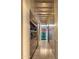 Bright hallway with hardwood floors, built-in shelves, cabinets, and a decorative glass window feature at the end at 30600 N Pima Rd # 61, Scottsdale, AZ 85266