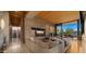 A spacious living room with a stone wall, hardwood ceiling, and outdoor access through sliding glass doors at 30600 N Pima Rd # 61, Scottsdale, AZ 85266
