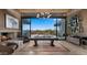 Spacious living room with a stone fireplace, pool table, and a beautiful view of the outdoor desert landscape at 30600 N Pima Rd # 61, Scottsdale, AZ 85266