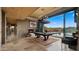 Open-concept living room with a fireplace, pool table, and sliding glass doors to the backyard pool at 30600 N Pima Rd # 61, Scottsdale, AZ 85266