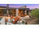 Inviting outdoor living space with a cozy fireplace, comfortable seating, and desert landscaping at 30600 N Pima Rd # 61, Scottsdale, AZ 85266