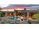 Desert home features a sparkling pool, cozy fireplace, outdoor seating, and beautiful desert landscaping at 30600 N Pima Rd # 61, Scottsdale, AZ 85266