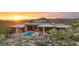Exterior view of a desert home with a pool, outdoor seating, and sunset views at 30600 N Pima Rd # 61, Scottsdale, AZ 85266