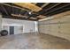 Open garage with visible rafters, a large roll-up door, and smooth flooring at 3218 W Clinton St, Phoenix, AZ 85029