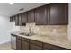 A kitchen showcases wooden cabinets, stone countertops, a stainless dishwasher, and a stainless steel sink at 3218 W Clinton St, Phoenix, AZ 85029