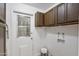 The laundry area shows a door, overhead cabinets, and utility hookups against white walls at 3218 W Clinton St, Phoenix, AZ 85029