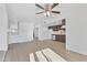Bright room featuring light wood flooring, a ceiling fan, and an open layout to the kitchen at 3218 W Clinton St, Phoenix, AZ 85029