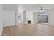 Bright living room featuring light wood flooring, a cozy fireplace, and a ceiling fan at 3218 W Clinton St, Phoenix, AZ 85029