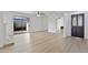 Open-concept living room featuring light wood floors, mirrored wall, and access to outdoor patio at 3218 W Clinton St, Phoenix, AZ 85029