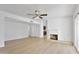 Bright living room featuring light wood flooring, a cozy fireplace, and a ceiling fan at 3218 W Clinton St, Phoenix, AZ 85029