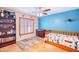 Cheerful bedroom with blue accent wall, shuttered window, ceiling fan and wood flooring at 3597 W Mineral Butte Dr, San Tan Valley, AZ 85144