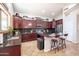 Bright kitchen with rich cabinetry, island with seating, and modern stainless steel appliances at 3597 W Mineral Butte Dr, San Tan Valley, AZ 85144