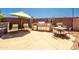 Outdoor kitchen features a built-in grill, dining area, and comfortable lounge chairs with a shade umbrella at 3597 W Mineral Butte Dr, San Tan Valley, AZ 85144