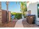 Landscaped side yard with a walkway leading to the backyard, featuring desert plants and a secure fence at 3597 W Mineral Butte Dr, San Tan Valley, AZ 85144