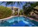 Beautiful pool area with a view of the home, complemented by mature landscaping and palm trees at 3821 W Barcelona Dr, Chandler, AZ 85226