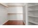 Spacious walk-in closet features wood shelving, hanging rods, and hardwood floors for ample storage at 3821 W Barcelona Dr, Chandler, AZ 85226