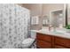 Well-lit bathroom featuring a shower with a decorative curtain, modern fixtures, and fresh towels at 41280 W Sanders Way, Maricopa, AZ 85138