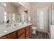 Well-lit bathroom with dual sinks, spacious vanity, and a glass-enclosed shower, blending style and functionality at 41280 W Sanders Way, Maricopa, AZ 85138