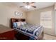 Cozy bedroom with a ceiling fan, stylish quilt, and a window for natural light at 41280 W Sanders Way, Maricopa, AZ 85138