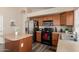 Functional kitchen with stainless steel refrigerator, oak cabinets, a kitchen island, and modern black gas range at 41280 W Sanders Way, Maricopa, AZ 85138