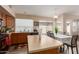 Bright kitchen featuring wooden cabinets, island, and adjacent dining area, perfect for Gathering meals and entertaining at 41280 W Sanders Way, Maricopa, AZ 85138