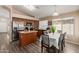 Bright eat-in kitchen features wood cabinetry, stainless steel appliances, and laminate flooring at 41280 W Sanders Way, Maricopa, AZ 85138