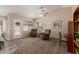 Comfortable living room with carpet and vinyl flooring, featuring a ceiling fan and an access door at 41280 W Sanders Way, Maricopa, AZ 85138