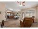 Open-concept living room featuring carpet and vinyl flooring adjacent to a dining area and kitchen at 41280 W Sanders Way, Maricopa, AZ 85138