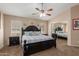 Cozy bedroom with large bed, ceiling fan, mirrored closet doors, and natural light from multiple windows at 41280 W Sanders Way, Maricopa, AZ 85138