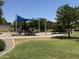 Playground with slides, shade covers, and picnic tables in a community park at 41280 W Sanders Way, Maricopa, AZ 85138