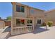 Back exterior view of a two-story home with covered patio and backyard pool view at 42812 W Venture Rd, Maricopa, AZ 85138