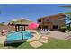 Beautiful backyard featuring a pool with waterfall, tanning ledge, and outdoor seating area at 42812 W Venture Rd, Maricopa, AZ 85138