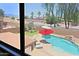 Backyard oasis with private pool, lush landscaping, and mountain views seen through a window at 42812 W Venture Rd, Maricopa, AZ 85138