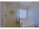 Bathroom features a shower with glass door, a soaking tub, and a small window at 42812 W Venture Rd, Maricopa, AZ 85138