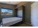 Spacious guest bedroom featuring a murphy bed and a window with a neighborhood view, maximizing space and style at 42812 W Venture Rd, Maricopa, AZ 85138