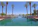 Beautiful community lake featuring fountains, palm trees, and stone accents, perfect for relaxation at 42812 W Venture Rd, Maricopa, AZ 85138