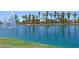 Picturesque lake with stunning fountain features, palm trees, and well-kept grassy areas, creating a serene atmosphere at 42812 W Venture Rd, Maricopa, AZ 85138